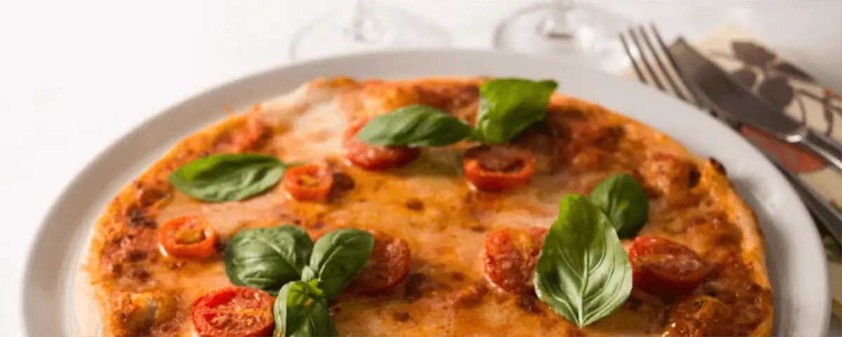 Köstliche Pizza mit Basilikum und Tomaten.