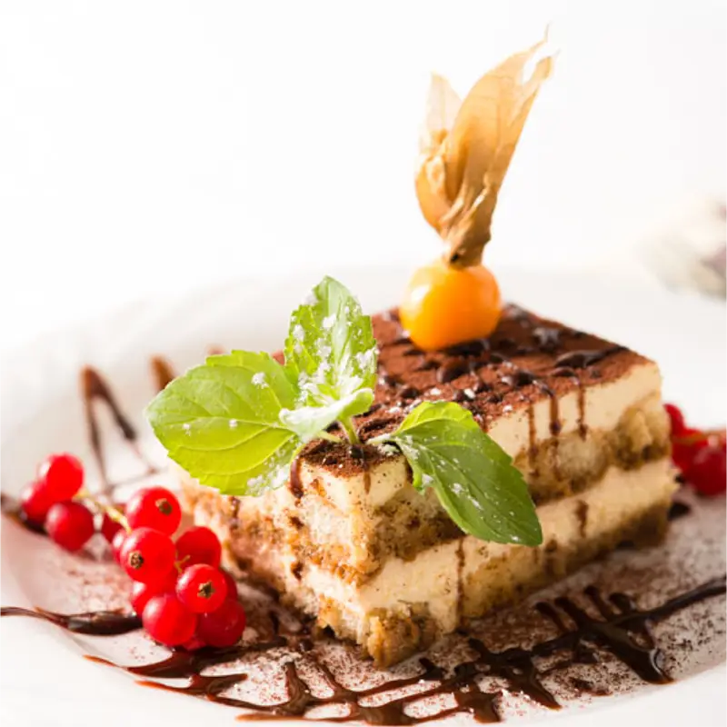 Tiramisu angerichtet mit Minze, Beeren und Physalis.