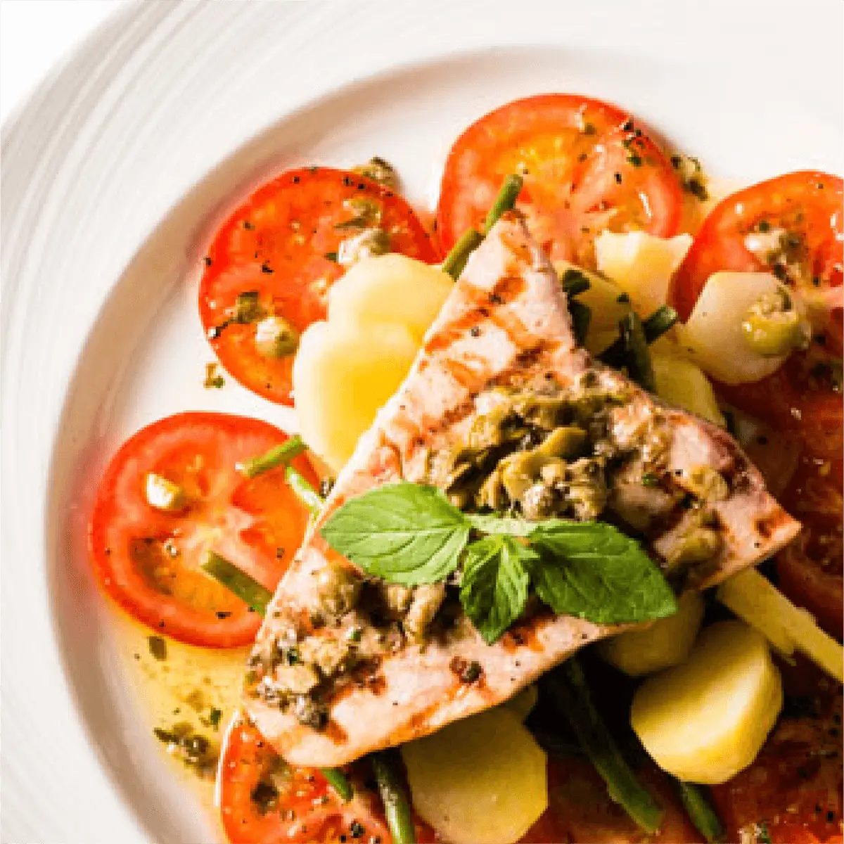 Ein Stück Fleisch mit Pilzen, Tomate und Kartoffel.