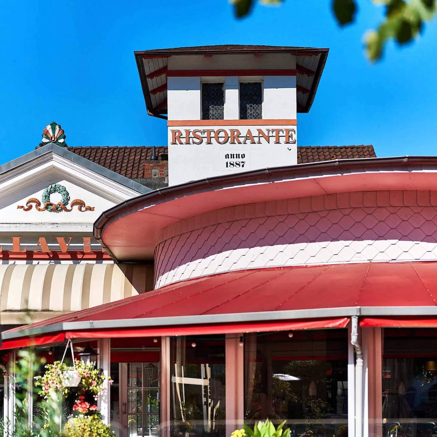 Bild von dem Gebäudedach auf dem in großen Buchstaben Ristorante anno 1887 steht.