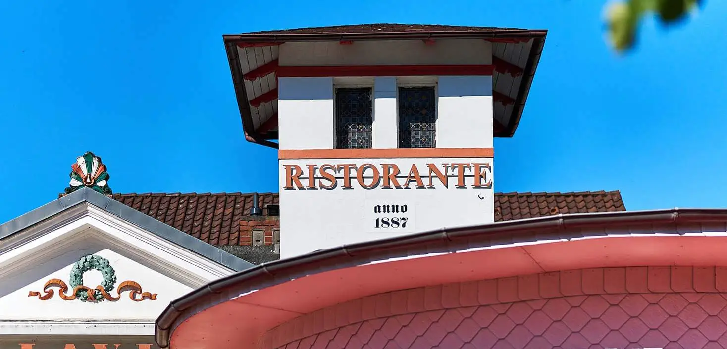 Bild von dem Gebäudedach auf dem in großen Buchstaben Ristorante anno 1887 steht.